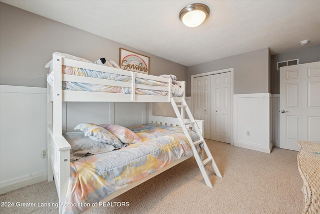 bedroom featuring light colored carpet and a closet