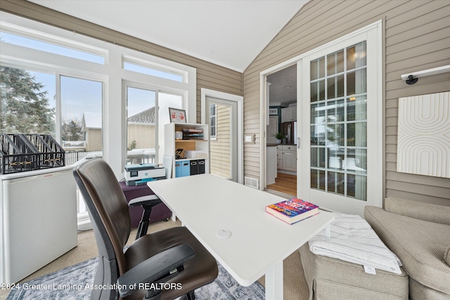 home office with vaulted ceiling and wooden walls