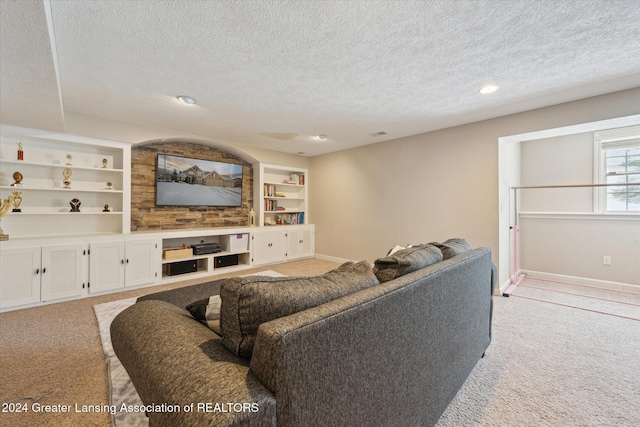 living room featuring light carpet, a textured ceiling, and built in features