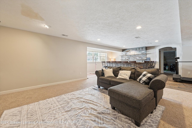 carpeted living room featuring a textured ceiling