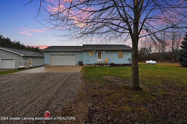 ranch-style house featuring a yard and a garage