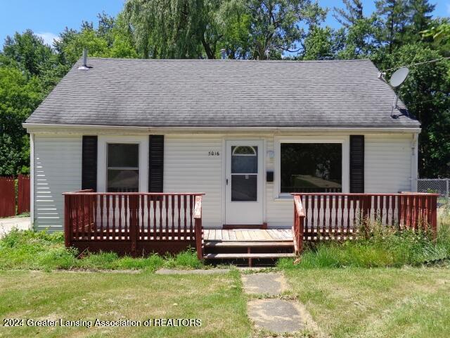 view of front facade featuring a front yard and a deck