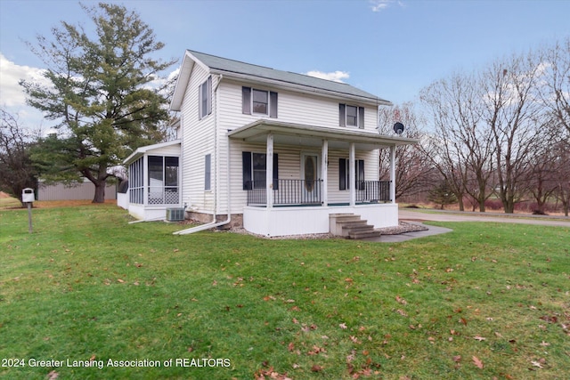 view of front of house featuring a sunroom, covered porch, central air condition unit, and a front yard