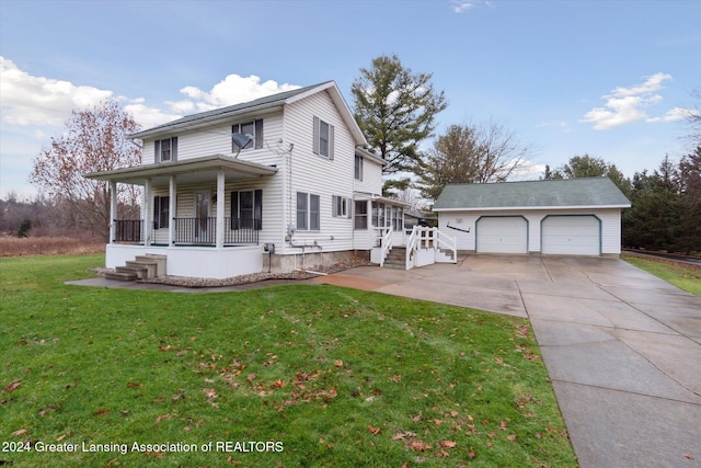 view of front of home featuring a porch, a garage, an outbuilding, and a front yard