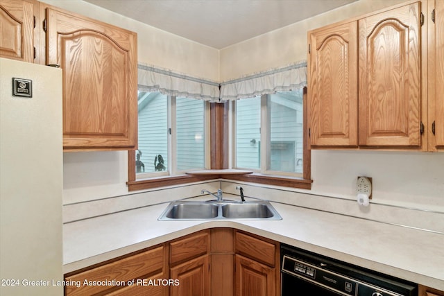 kitchen with dishwasher, white refrigerator, and sink