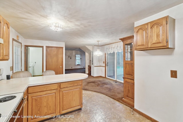 kitchen featuring kitchen peninsula, electric range, light colored carpet, and decorative light fixtures