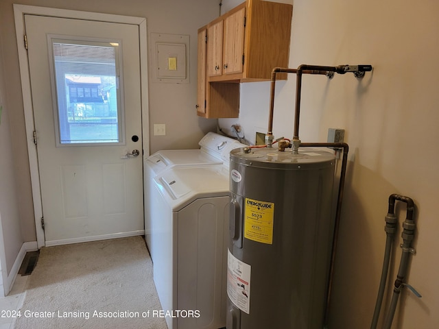 washroom featuring water heater, washer and dryer, and cabinets