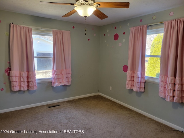 empty room featuring carpet flooring and ceiling fan