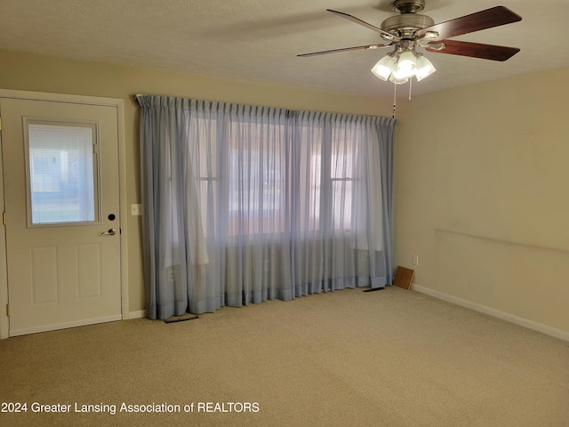 interior space with ceiling fan and a textured ceiling