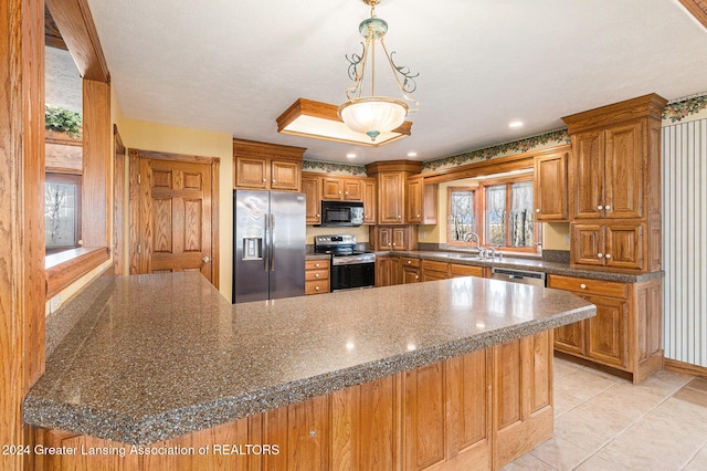 kitchen with sink, kitchen peninsula, pendant lighting, light tile patterned floors, and appliances with stainless steel finishes