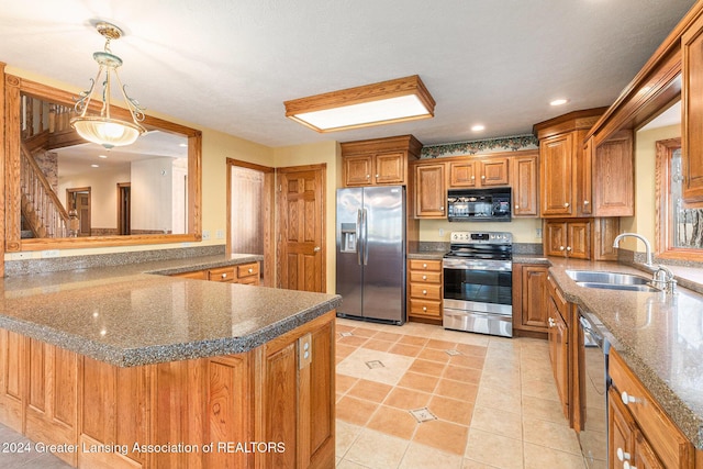 kitchen with hanging light fixtures, sink, dark stone countertops, light tile patterned floors, and appliances with stainless steel finishes