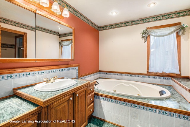 bathroom with vanity and tiled tub