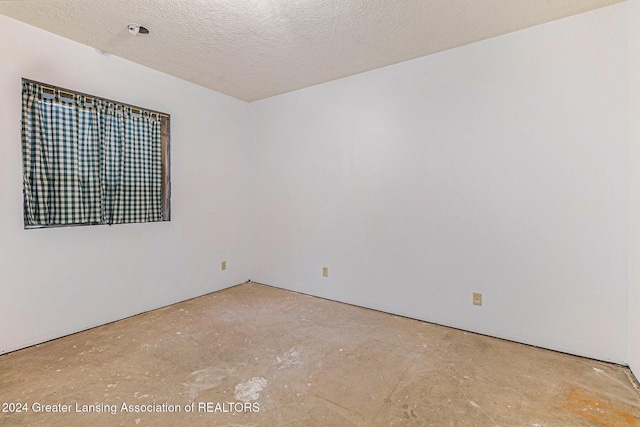 unfurnished room featuring a textured ceiling