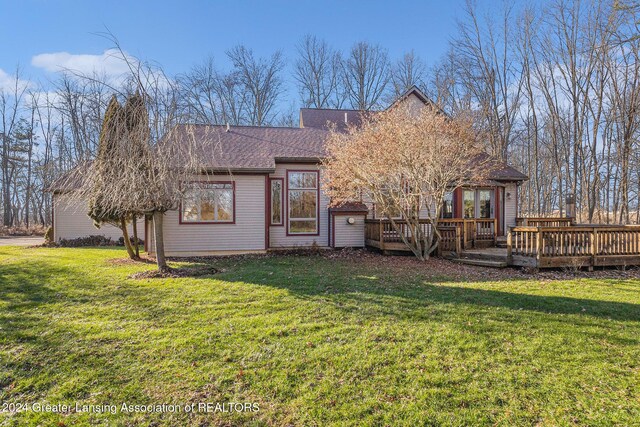 rear view of house with a lawn and a deck