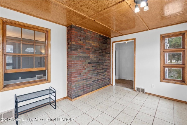 unfurnished room with wooden ceiling and brick wall