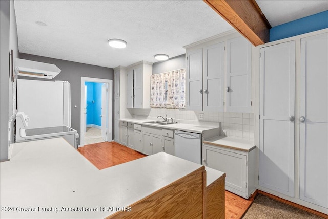 kitchen with backsplash, white appliances, sink, and a textured ceiling