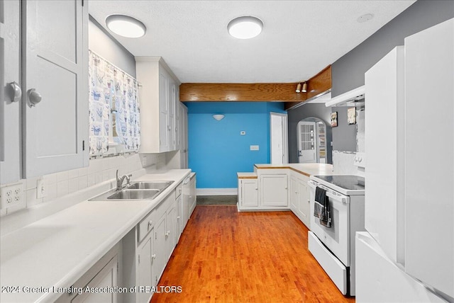 kitchen featuring decorative backsplash, sink, light hardwood / wood-style flooring, white range with electric cooktop, and white cabinetry