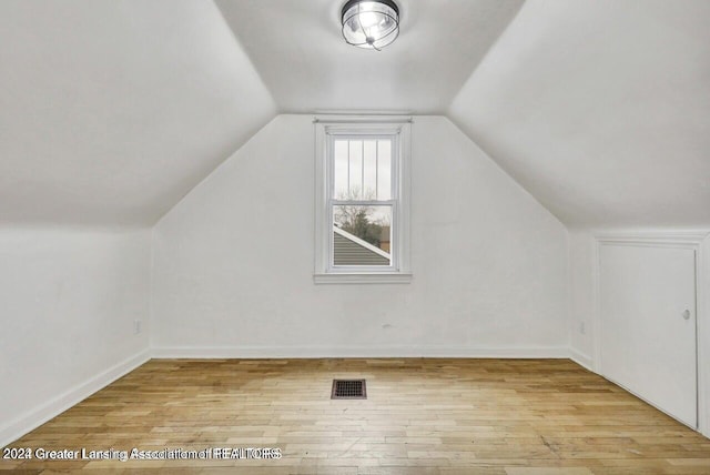 additional living space with lofted ceiling and light hardwood / wood-style flooring