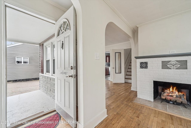 336 S Waverly Rd, Lansing, MI 48917 - hall with wood-type flooring, ornamental molding, stairs, baseboards, and arched walkways