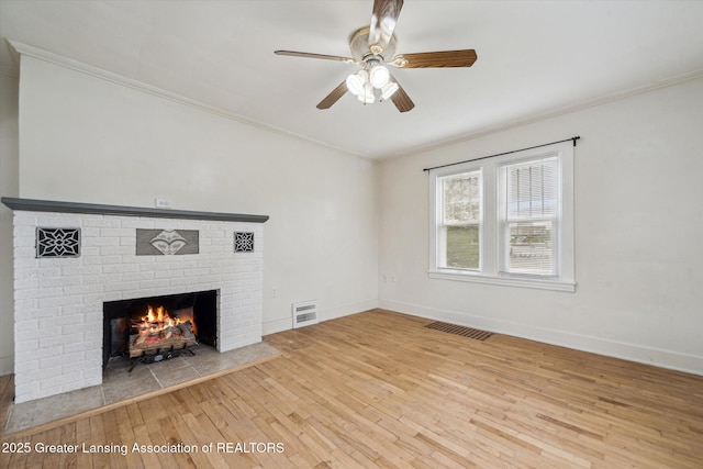 336 S Waverly Rd, Lansing, MI 48917 - unfurnished living room with wood-type flooring, ornamental molding, a fireplace, a ceiling fan, and baseboards