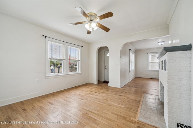 336 S Waverly Rd, Lansing, MI 48917 - empty room with ornamental molding, arched walkways, light wood-type flooring, a ceiling fan, and baseboards