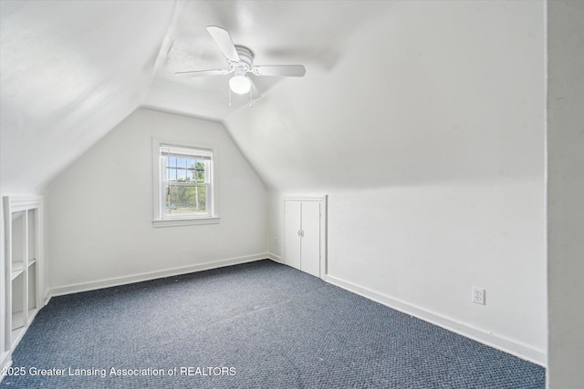 336 S Waverly Rd, Lansing, MI 48917 - additional living space with vaulted ceiling, dark carpet, a ceiling fan, and baseboards
