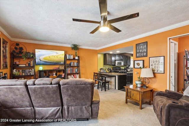 living room with ceiling fan, ornamental molding, light carpet, and a textured ceiling