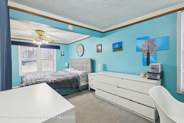 bedroom featuring light carpet, a textured ceiling, ceiling fan, and ornamental molding