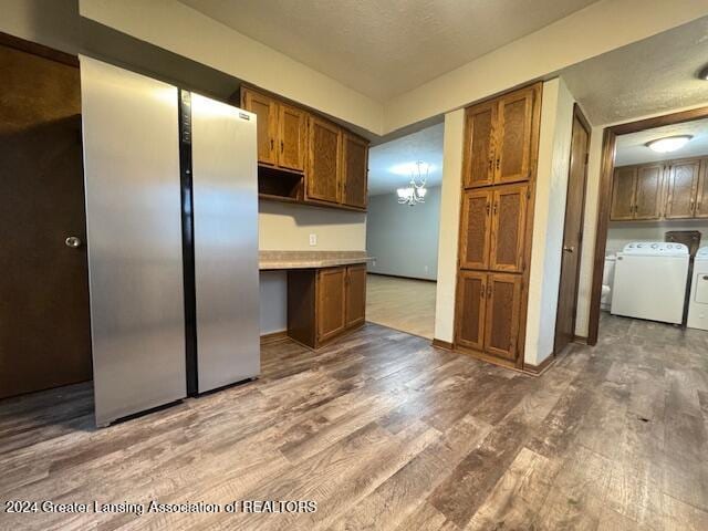 kitchen with a chandelier, washing machine and dryer, and dark hardwood / wood-style floors