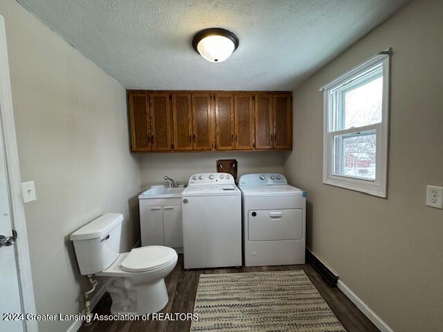 laundry area with independent washer and dryer, dark hardwood / wood-style flooring, and a textured ceiling