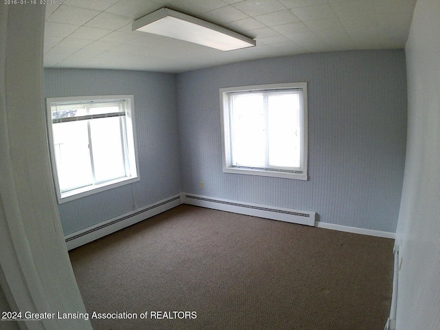 unfurnished room featuring carpet floors and baseboard heating