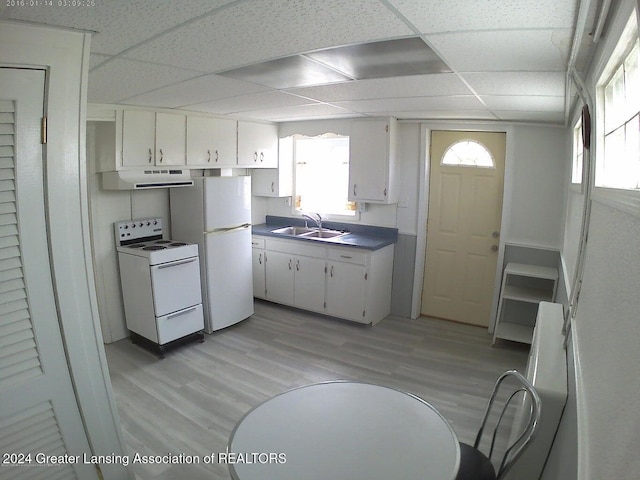 kitchen with a paneled ceiling, white appliances, sink, light wood-type flooring, and white cabinetry