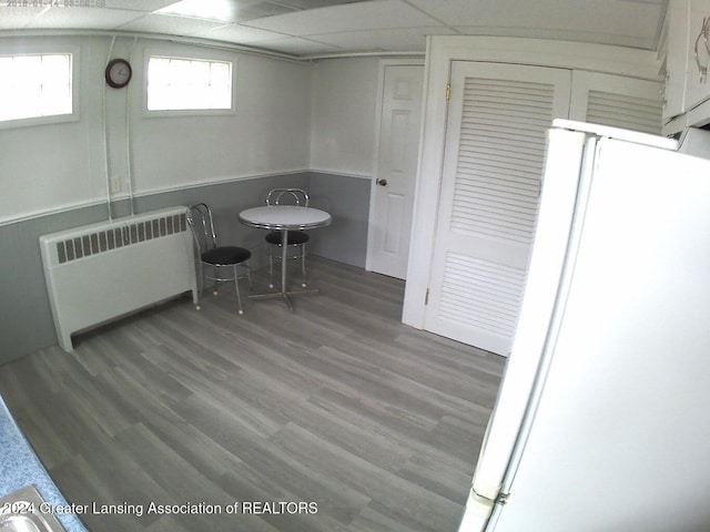 dining room featuring a paneled ceiling, wood-type flooring, and radiator