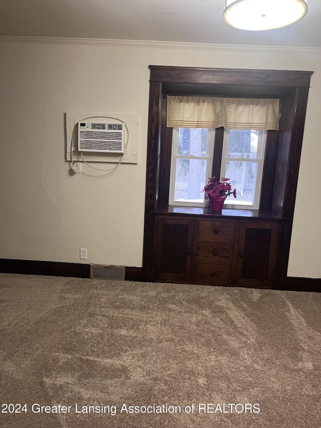 carpeted foyer with a wall unit AC and ornamental molding