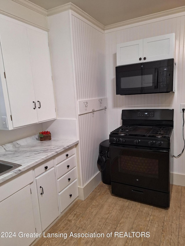 kitchen with black appliances, white cabinets, crown molding, light wood-type flooring, and light stone counters