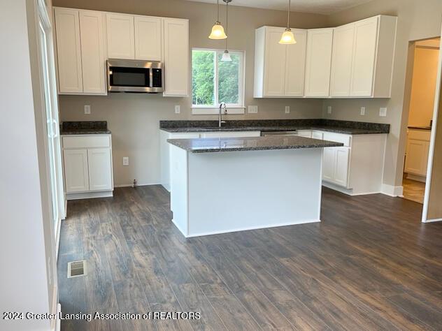 kitchen with white cabinets, pendant lighting, dark hardwood / wood-style flooring, and sink