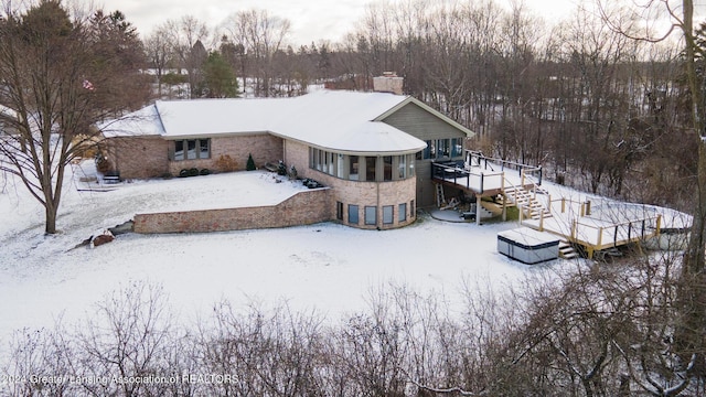 snow covered property with a wooden deck