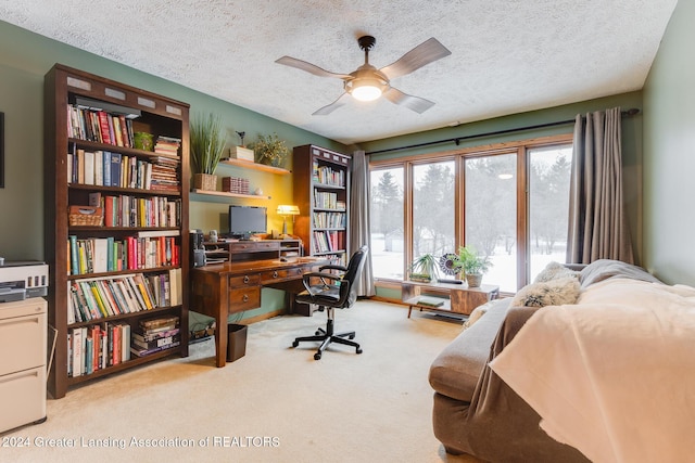 carpeted office featuring ceiling fan and a textured ceiling