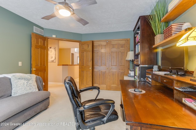 carpeted home office with ceiling fan, sink, and a textured ceiling