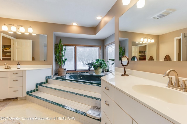 bathroom featuring tiled tub, tile patterned flooring, and vanity