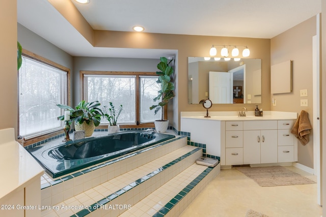 bathroom with vanity and tiled bath