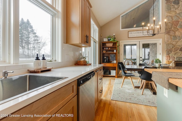 kitchen featuring dishwasher, french doors, hanging light fixtures, decorative backsplash, and light hardwood / wood-style floors