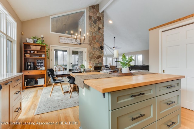 kitchen featuring french doors, light wood-type flooring, ceiling fan with notable chandelier, vaulted ceiling with beams, and butcher block countertops