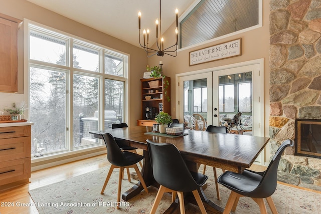 dining space with light hardwood / wood-style floors, an inviting chandelier, and french doors