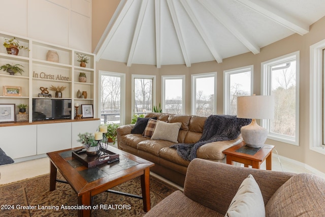 living room featuring vaulted ceiling with beams and a healthy amount of sunlight