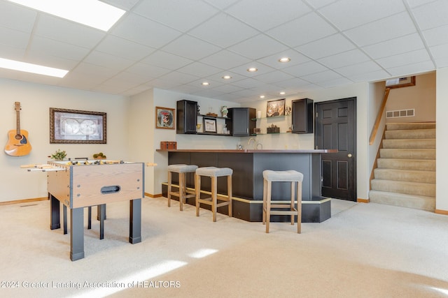 rec room featuring indoor bar and light colored carpet