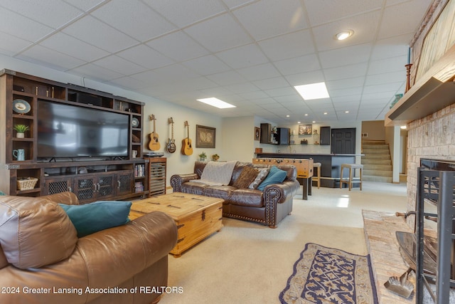 carpeted living room with a paneled ceiling