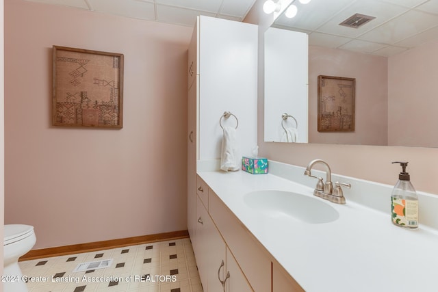 bathroom with vanity, a paneled ceiling, and toilet