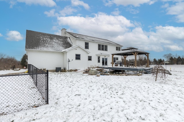 snow covered rear of property featuring a gazebo