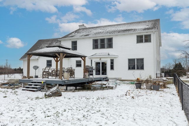 snow covered house featuring a gazebo and a wooden deck